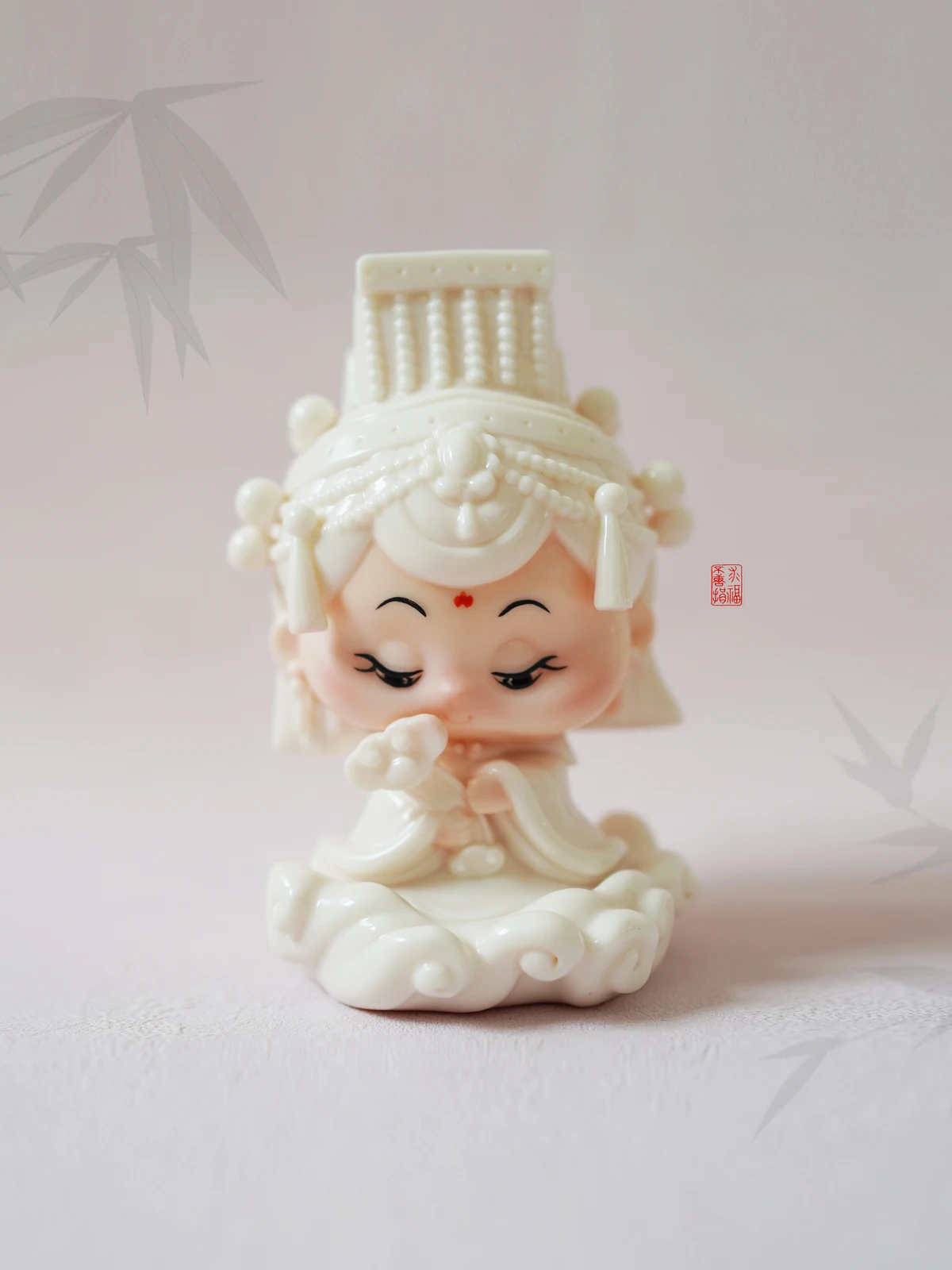 浅色布面上的妈祖团团白瓷手办。